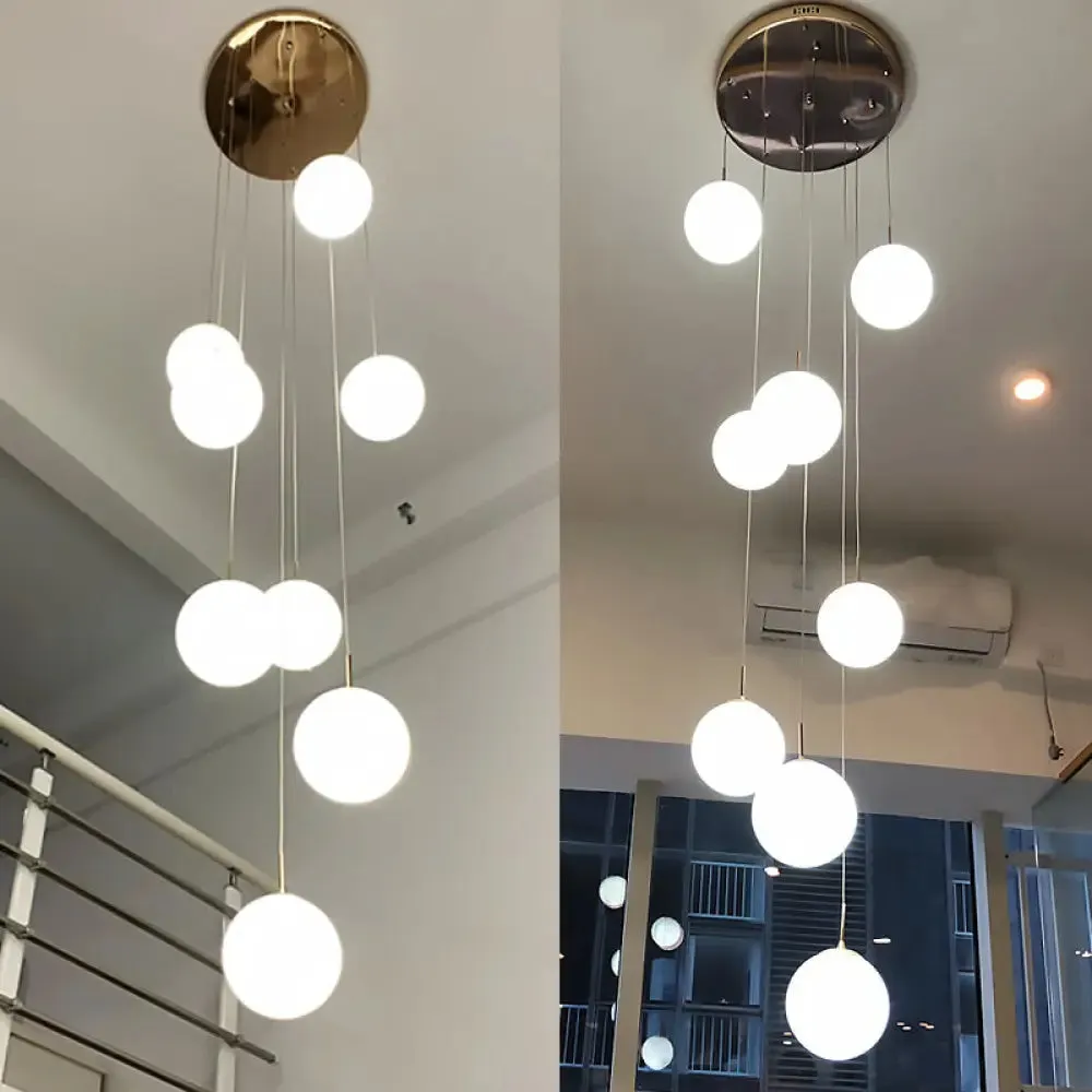 Minimalist Gold Multi-Pendant Ceiling Light with Cream Glass Bubbles and White Glass Staircase Suspension